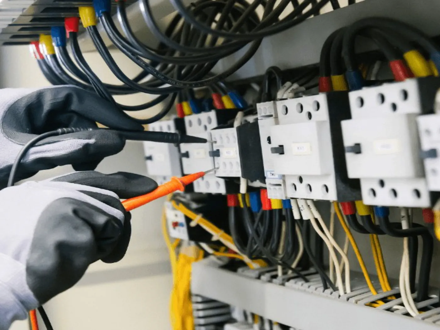 Electrician testing an electrical panel with a test probe